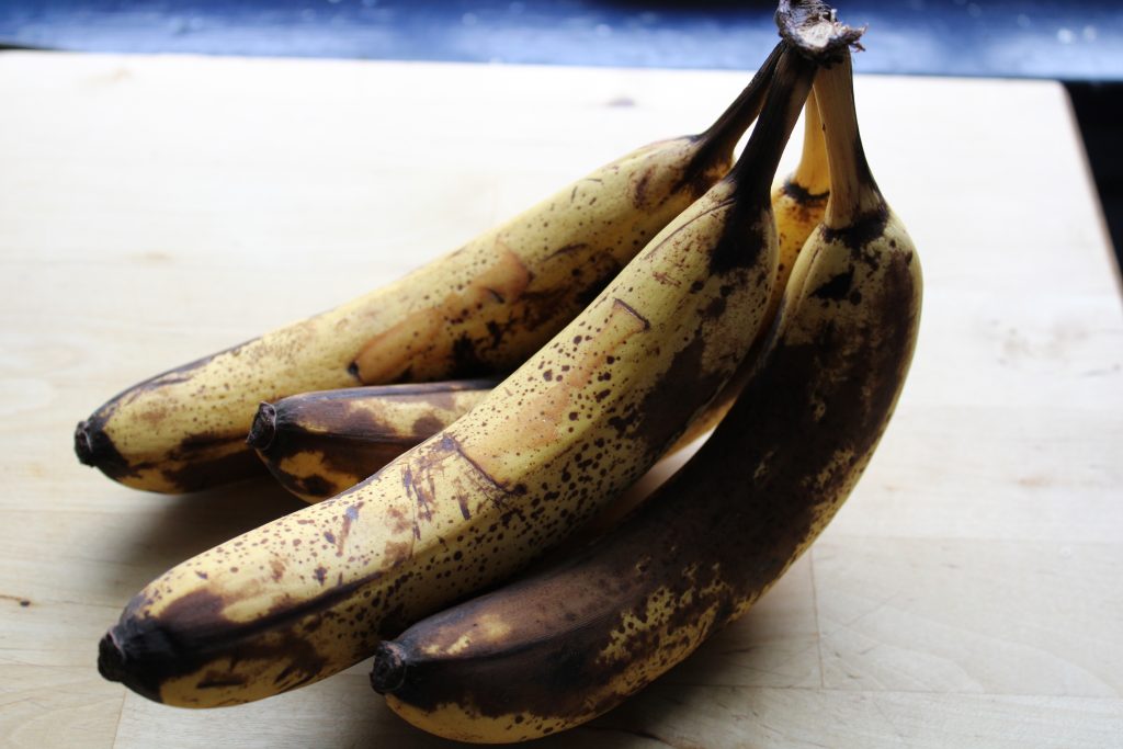Image of 4 over-ripe bananas on wooden countertop