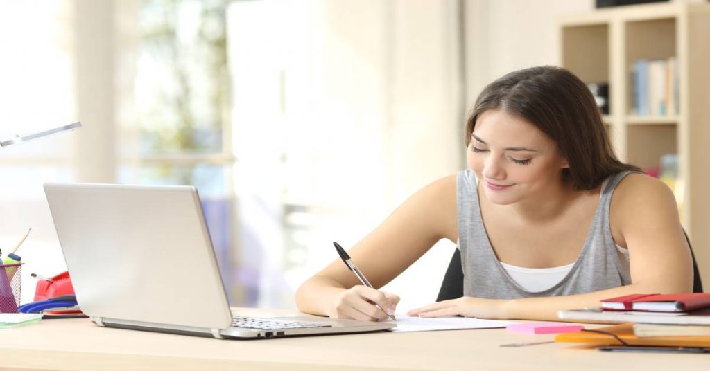 5 simple writing assignment tips for parents photo of teen girl writing at a desk with open laptop .